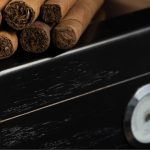 Cigars on top of a black humidor