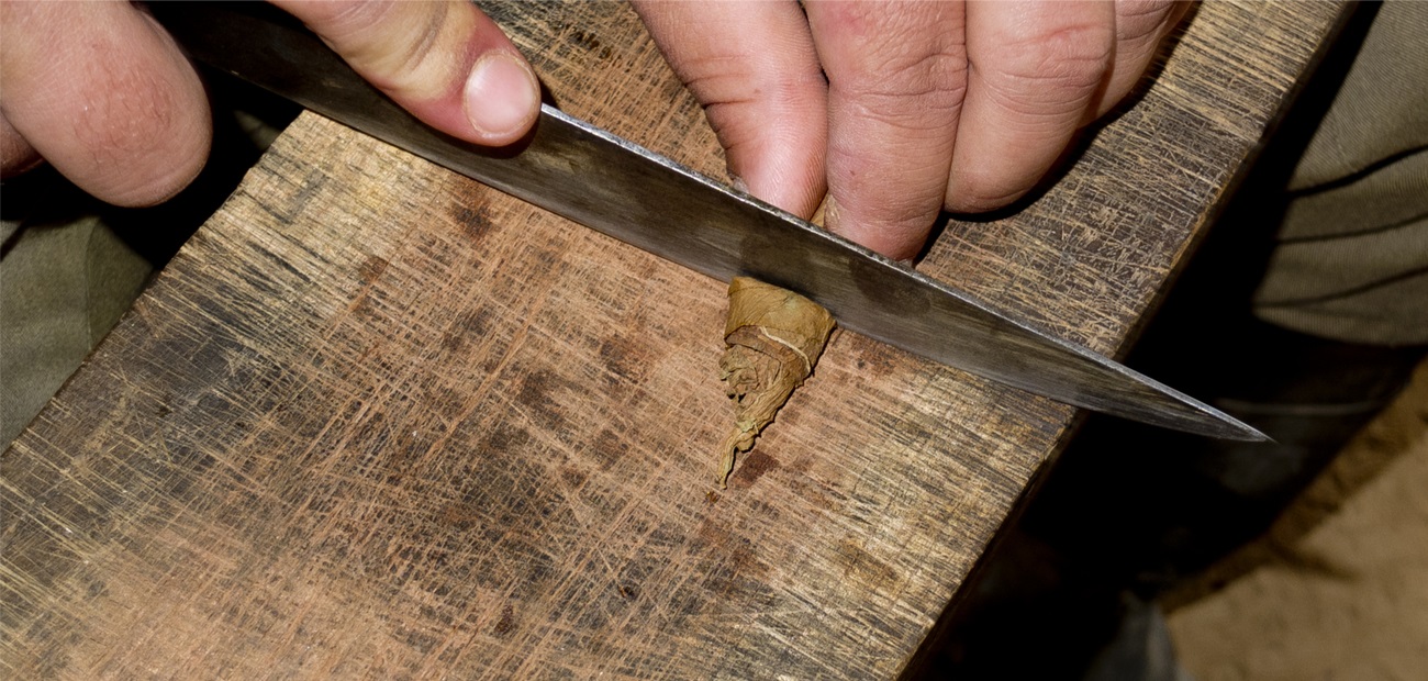 knife cutting the tip of a Cuban cigar