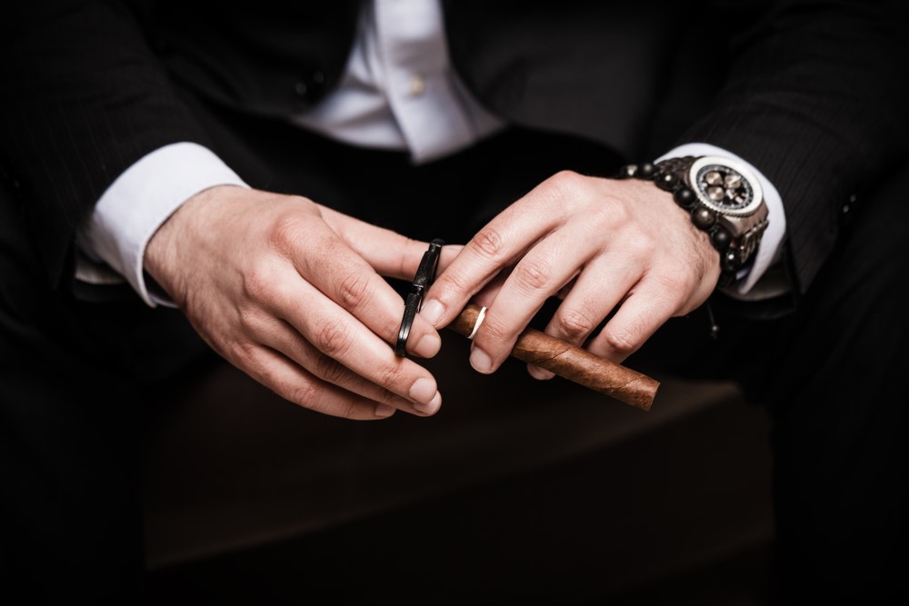 man hand holding cigar and clipper